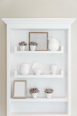Fototapeta na wymiar White shelf with vintage porcelain tableware in house.