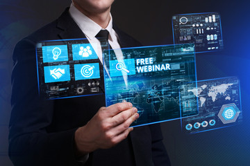 Business, Technology, Internet and network concept. Young businessman working on a virtual screen of the future and sees the inscription: Free webinar