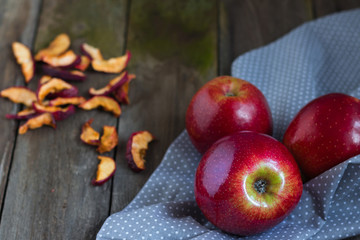 Red apples on wooden table. Healthy food. Fresh and dried apples