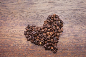 Cup of coffee and beans over wooden background