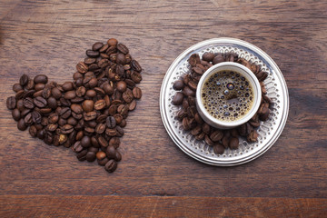Cup of coffee and beans over wooden background