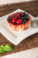 Fresh berry tartlet or cake filled with custard, raspberry, blueberry redcurrant and blackberry delicious dessert, easy diet. Close up