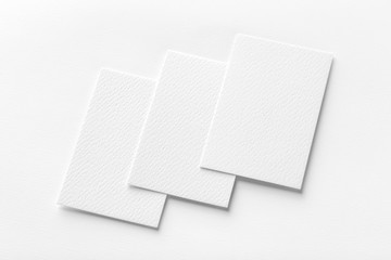 Mockup of three vertical business cards at white textured background.