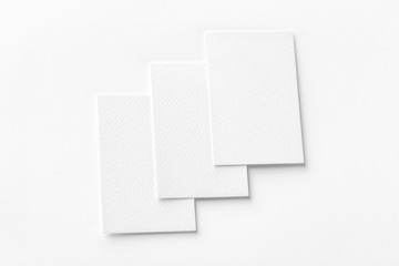 Mockup of three vertical business cards at white textured background.