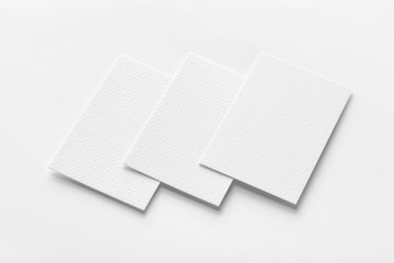 Mockup of three vertical business cards at white textured background.