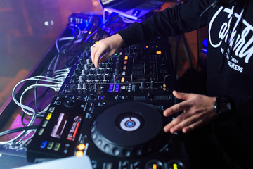 DJ playing music at mixer closeup.