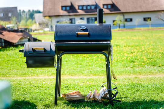 Preparing Delicious Meat In Slow Cooking Smoker In Backyard.