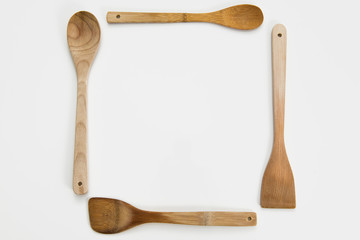 Wooden spoons arranged in a square on white background