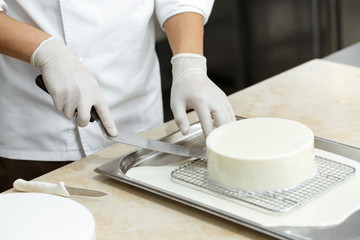 Obraz na płótnie Canvas Young professional chef glazing a delicious cake