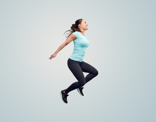happy smiling sporty young woman jumping in air