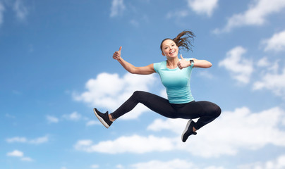 Obraz premium happy sporty young woman jumping in blue sky
