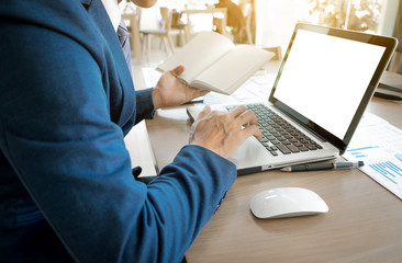 Young business man working with laptop, Book notes, man's hands on notebook computer, business person at workplace.