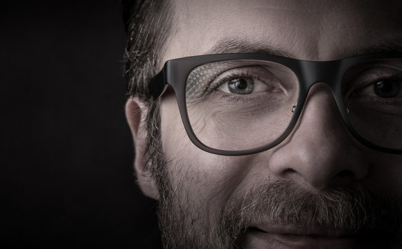 Eyes and glasses - man's face close up (macro)