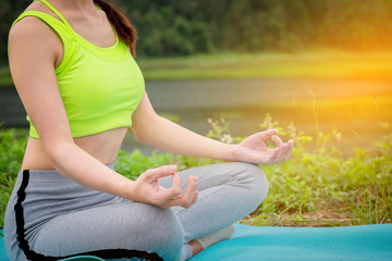 Fototapeta na wymiar young woman sitting Yoga near river. Concept of healthy lifestyle and relaxation.
