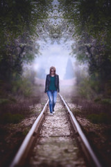 Fototapeta premium woman portrait over the long railroad, vintage sad expresion, ink toned