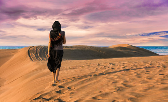 Frau in der Wüste läuft in Richtung Meer