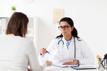 doctor with clipboard and woman at hospital