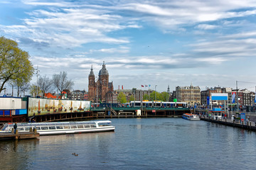 Canal boats and St Nicholas Church at Open Havenfront Amsterdam