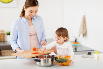 happy mother and baby cooking food at home kitchen