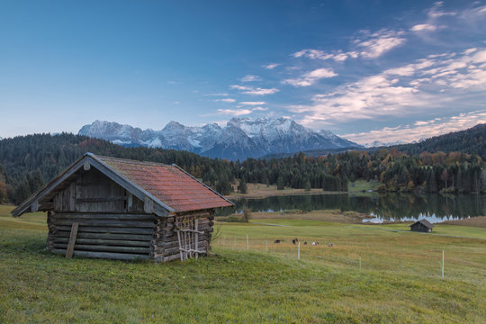 Wooden hut frames the alpine lake surrounded by the Alps, Geroldsee, Krun, Garmisch Partenkirchen, Upper Bavaria, Germany