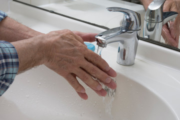 Hände am Waschbecken mit Wasser und Seife reinigen