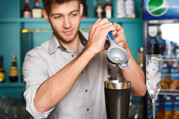 Barman making cocktail with lime