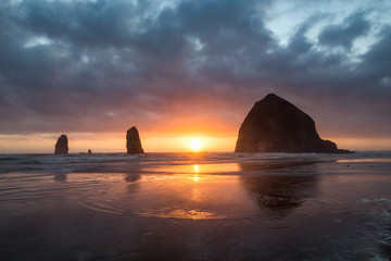 Sunset behind Haystack Rock at Cannon Beach on the Pacific Northwest coast, Oregon