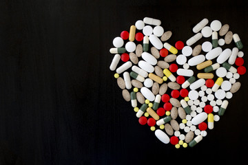 Bunch of various color pills in shape of heart