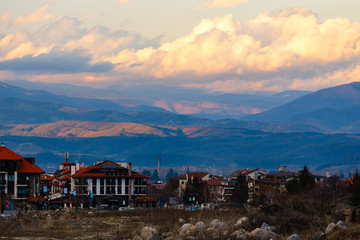 Landscape with view on small town with mountains and clouds