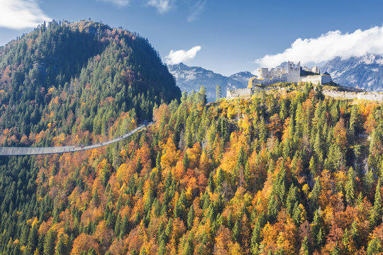 View of the old Ehrenberg Castle surrounded by colorful woods and suspension bridge, Highline 179, Reutte, Austria