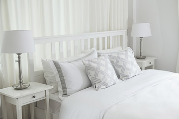 Fototapeta na wymiar Stylish white bedside table with modern lamp