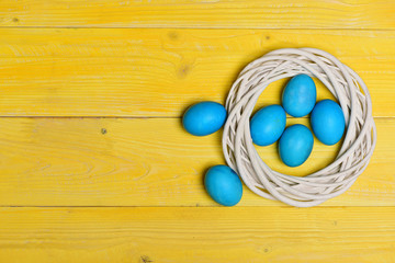 traditional eggs painted in blue color inside woven wooden wreath