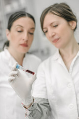 Two scientists holding a test tube with sample