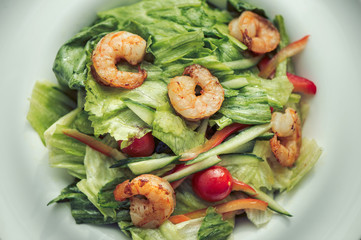 Shrimp salad in a white plate on a gray background. Food Concept