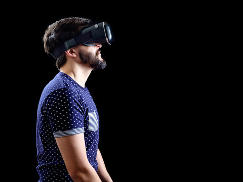 Man in blue dotted T-shirt wearing virtual reality 3d-headset