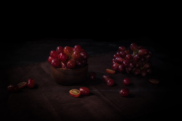 Rote Weintrauben in Szene gesetzt vor schwarzem Hintergrund