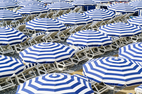 Blue and white beach parasols, Nice, Alpes Maritimes, Cote d'Azur, Provence, France, Mediterranean