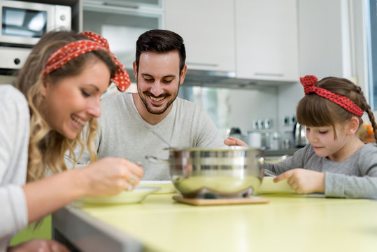 Young family in kitchen eating lunch