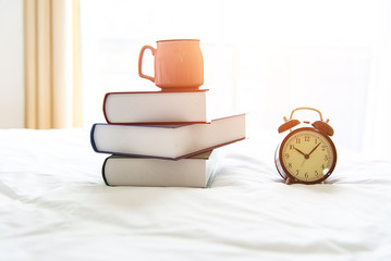 Retro alarm clock on stack books in bedroom