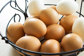 Fresh chicken eggs in a basket. The concept of Easter decor in natural colors. Selective focus. Close-up.