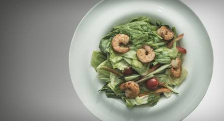 Shrimp salad in a white plate on a gray background. Food Concept