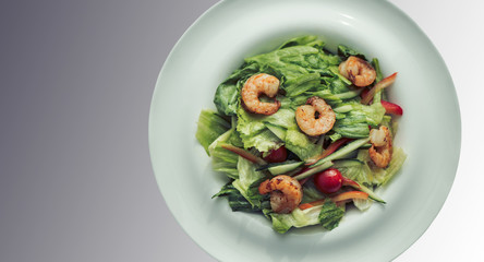 Shrimp salad in a white plate on a gray background. Food Concept