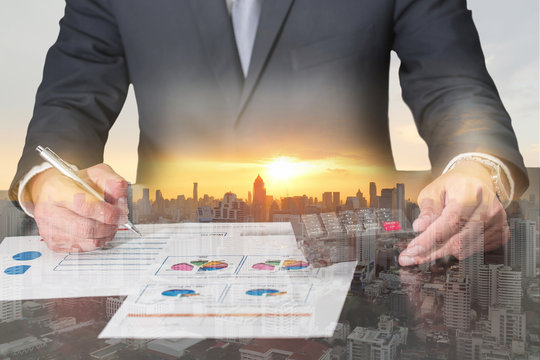 Double exposure of businessman working with document and calculator for analyze in the work, cityscape and sunset as analysis and commitment concept.