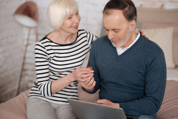 Senior woman giving some remedy to man