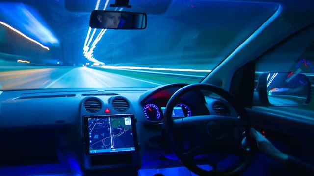 The man drive a car in the night highway. Inside view. Hyperlapse