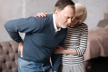 Obraz premium Senior man with terrible backache near wife