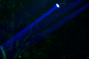 Fototapeta na wymiar Beam of blue light on black . Applied to a searchlight torch