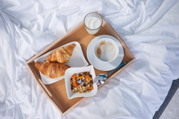 breakfast in bed with coffee and croissants. top view