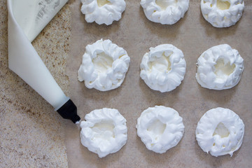 The cooking process Pavlova meringue pie with fresh strawberries on a background of brown stone.