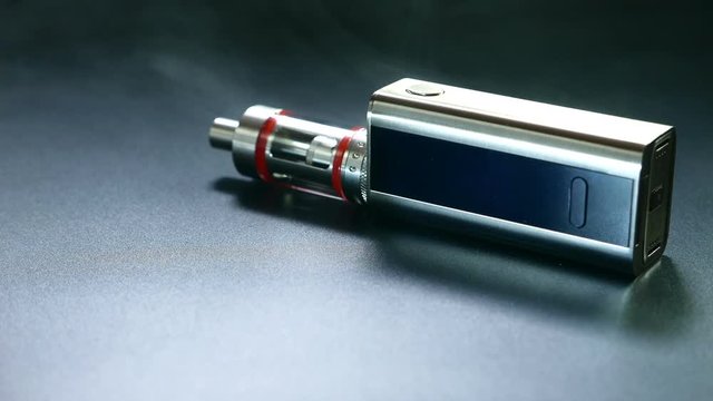 Electronic cigarette close-up on a black background in smoke